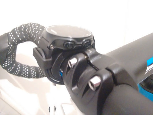 Close-up of a bike handlebar with a black and white glove on the left and a black bike bell on the right.